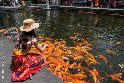 Female tourists feed fish at Tirta Empul, Bali's sacred water temple. photo