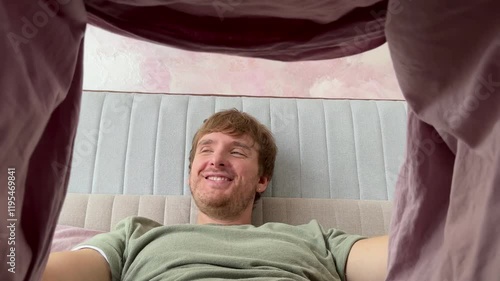 man looking under blanket and happy, feeling excited, concept men's health, bed