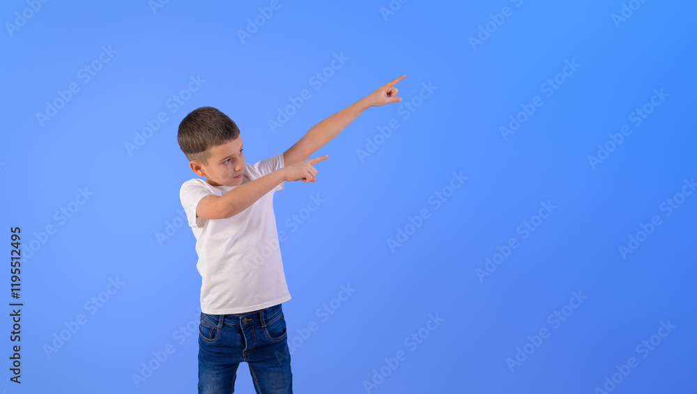 Portrait of adorable boy aiming at blank space and marketing new product on isolated blue background Portrait of adorable boy aiming at blank space and marketing new product on isolated blue background
