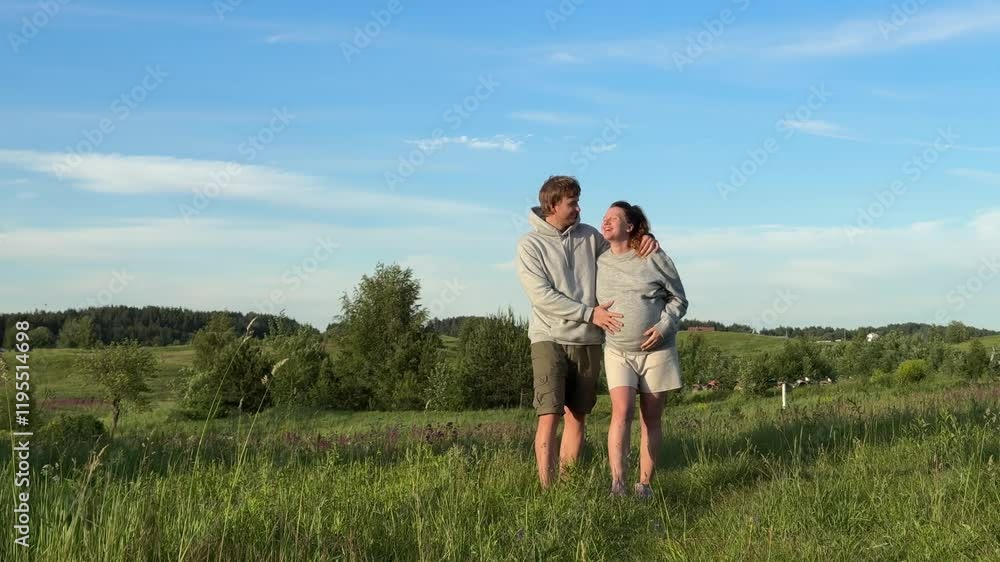 Happy couple, young family with pregnant woman walking outdoors at nature at summer day Happy couple, young family with pregnant woman walking outdoors at nature at summer day
