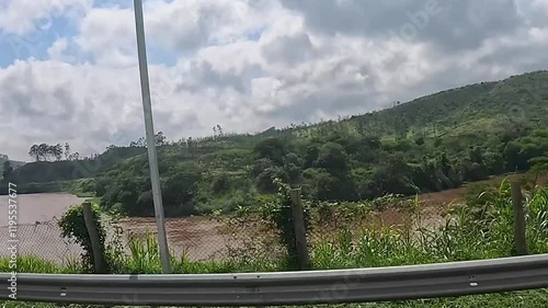 car passing by the road, the bridge, the highway, red car tip, river with clay