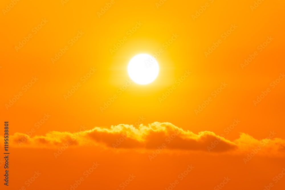Bright orange sunset casting warm light over soft clouds on the horizon during a peaceful evening sky Bright orange sunset casting warm light over soft clouds on the horizon during a peaceful evening sky