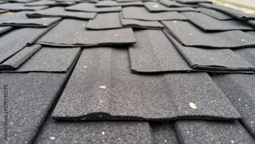Asphalt shingles showing cracks, curling edges, and granule loss from weather exposure over time.
