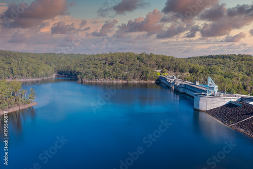 Photograph of the scenic Warragamba Dam wall and reservoir nestled amongst the natural landscape. The dam is a key water infrastructure utility in New South Wales, Australia.