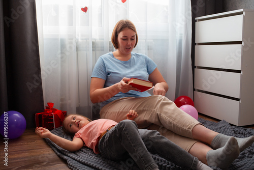 Caucasian woman speech therapist teaches a girl to pronounce sounds correctly. A woman and a child are reading a book together. The concept of preschool education photo