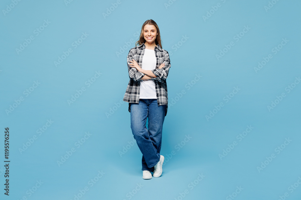 Full body young happy woman she wears checkered grey shirt casual clothes hold hands crossed folded look camera isolated on plain pastel light blue cyan background studio portrait. Lifestyle concept.
