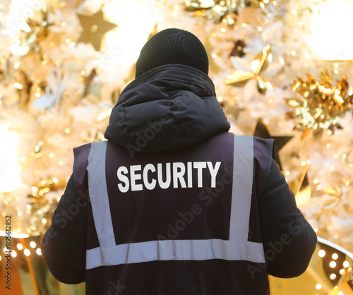 security guard on duty in a lavishly decorated shopping mall wearing a jacket with big security text photo