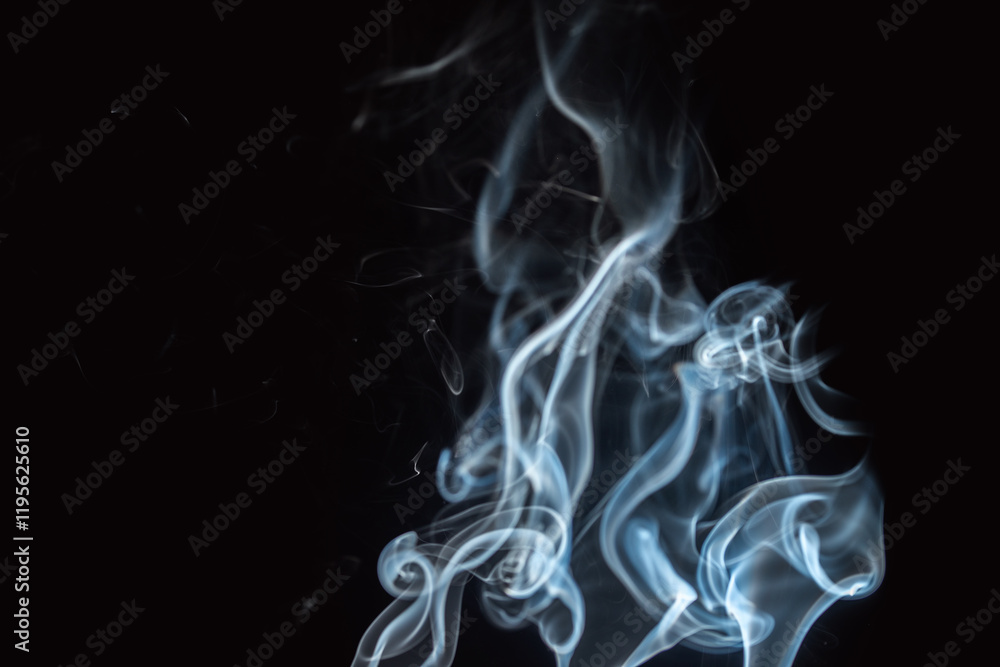 Smoke rises elegantly in dark background revealing intricate patterns and shapes Smoke rises elegantly in dark background revealing intricate patterns and shapes