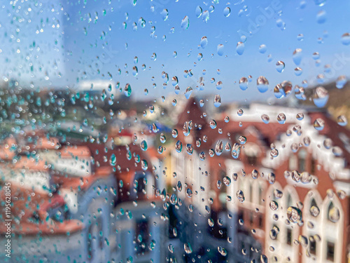 A candid, naturalistic view of a cityscape through a rain-spattered window photo