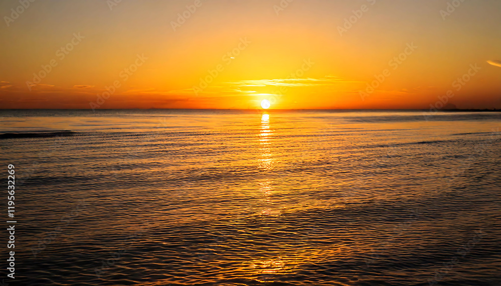 Obraz premium Stunning sunset over calm ocean waters. Golden hour light bathes the sea in warm hues, creating a tranquil and serene atmosphere. Perfect for travel, nature, and relaxation themes.