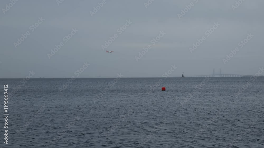 Passenger plane over the sea landing at the airport. Background of the sea and cloudy sky Passenger plane over the sea landing at the airport. Background of the sea and cloudy sky