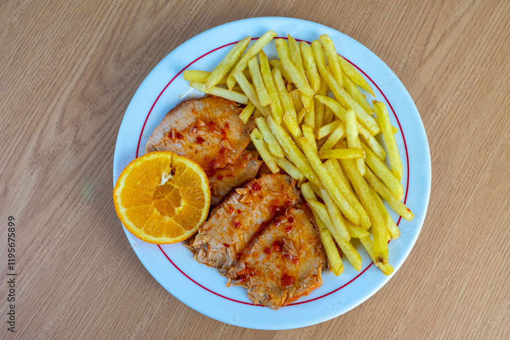 Roasted pork loin served with crispy fries on a traditional Portuguese restaurant table, showcasing authentic cuisine and warm dining ambiance. Roasted pork loin served with crispy fries on a traditional Portuguese restaurant table, showcasing authentic cuisine and warm dining ambiance.