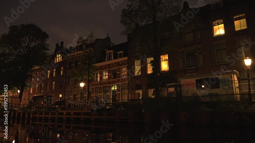 Cruising a canal at night past historic houses and vibrant graffiti