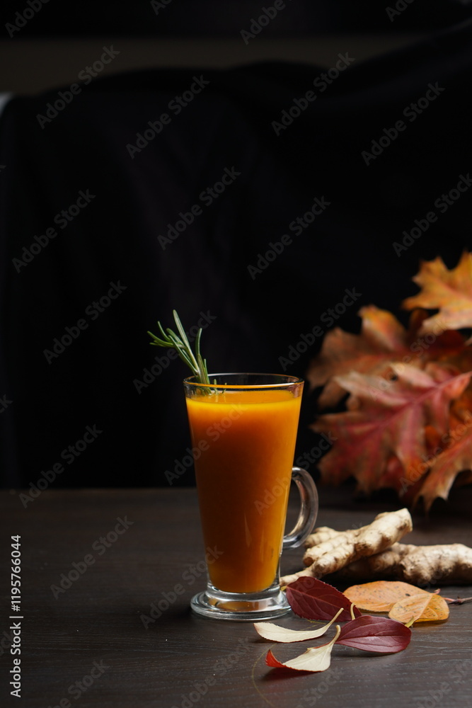 Sea buckthorn tea in a tall transparent mug on a black background Sea buckthorn tea in a tall transparent mug on a black background