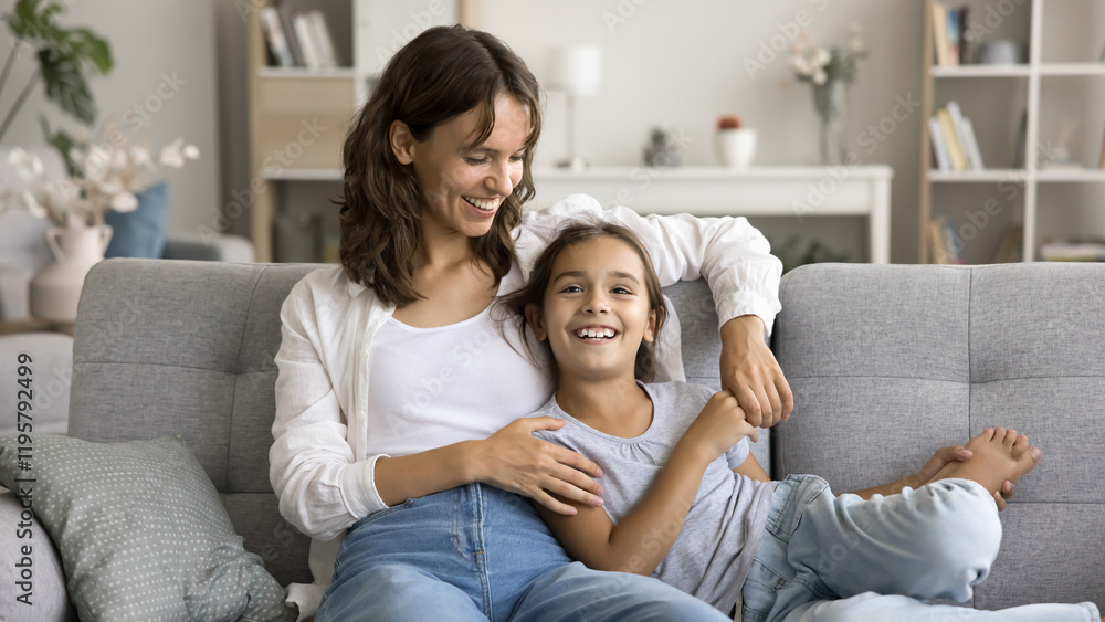 Lovely kid spend carefree leisure with young mother, smile, enjoy warm communication, talking seated on cozy couch in living room, having good harmonic relationships. Trust, motherhood, family rest Lovely kid spend carefree leisure with young mother, smile, enjoy warm communication, talking seated on cozy couch in living room, having good harmonic relationships. Trust, motherhood, family rest