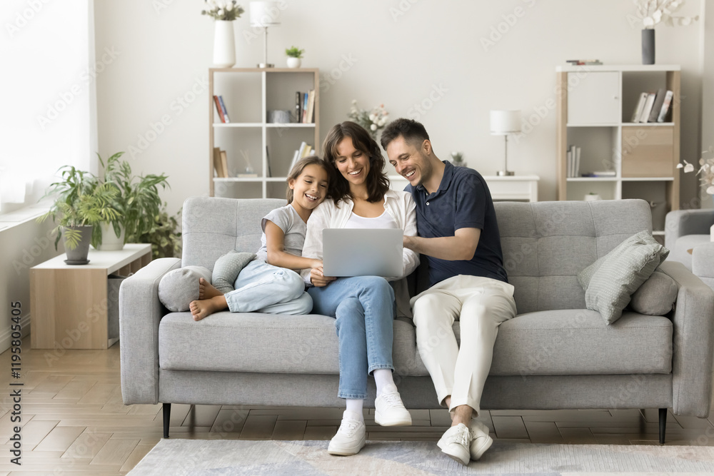 Married couple and little preschooler daughter sitting on couch using modern laptop, watching movies or educational cartoons, make online shopping via marketplaces platforms, spending weekend together Married couple and little preschooler daughter sitting on couch using modern laptop, watching movies or educational cartoons, make online shopping via marketplaces platforms, spending weekend together