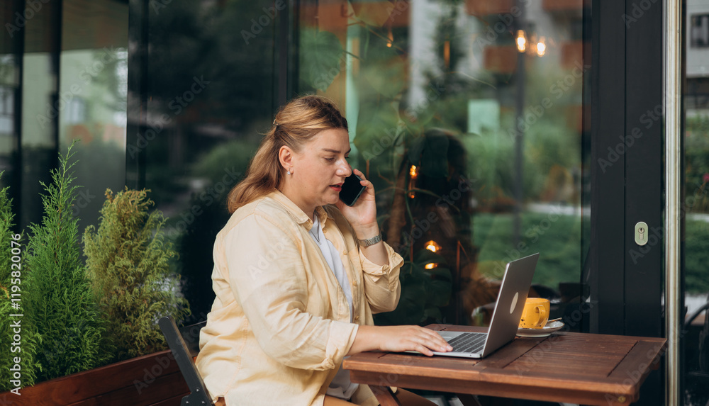 IT woman wear yellow shirt have conversation on phone, use laptop sit alone at table in coffee shop cafe restaurant and work or study. Successful businessman working in cafe outside.