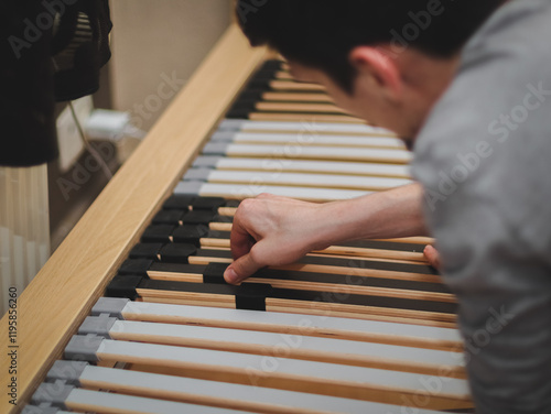 The guy inserts the frame slats into the plastic mount. photo