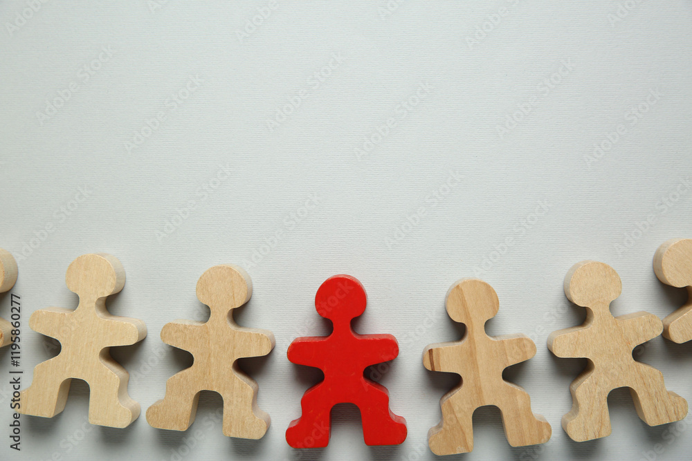 Obraz premium Personality concept. Red human figure among wooden ones on light grey background, flat lay. Space for text