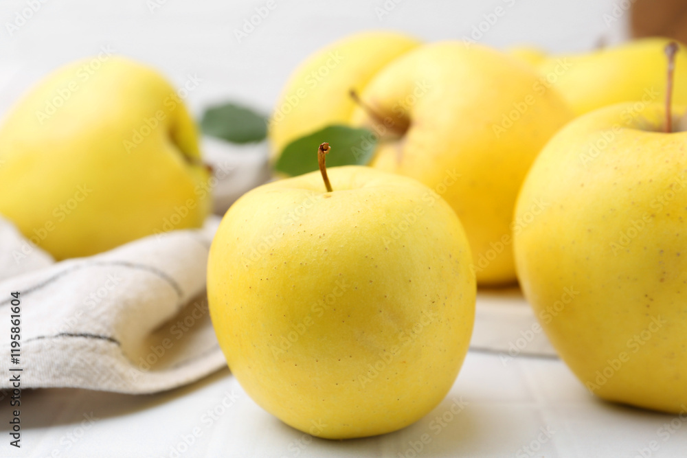 Fresh ripe yellow apples on white tiled table, closeup