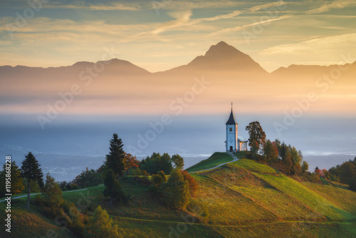 Aussicht auf eine kleine Kirche in Jamnik in der Nähe von Kranj bei Sonnenaufgang, Slowenien photo