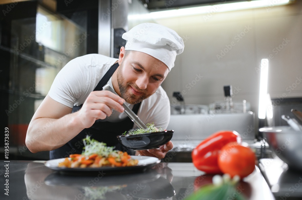 Closeup of a concentrated male chef garnishing food in the kitchen Closeup of a concentrated male chef garnishing food in the kitchen