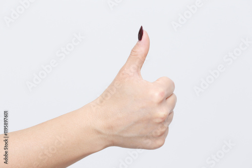 Thumb up gesture. Woman with beautiful manicure fingernails. Hand isolated on a gray background. Approval sign. Agreement symbol. Positivite gesture and I like it message. photo