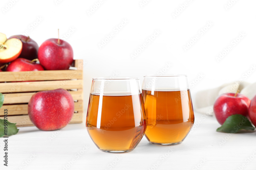 Fresh apple juice in glasses and fruits on white wooden table Fresh apple juice in glasses and fruits on white wooden table