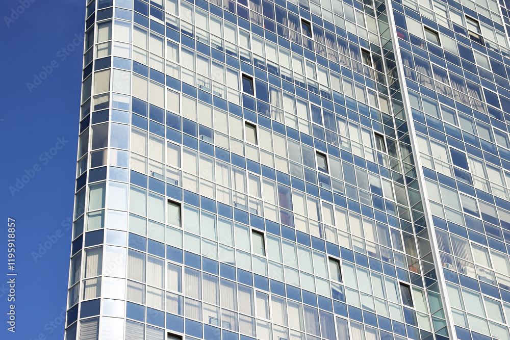 Fototapeta premium Exterior of modern building with many windows against blue sky, low angle view