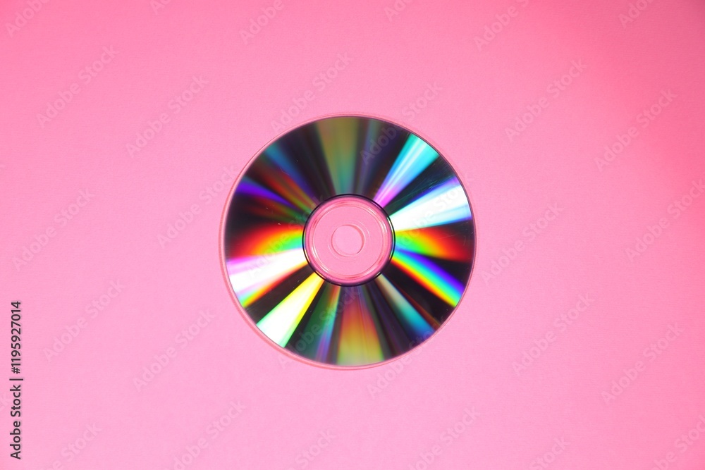 One shiny compact disc on pink background, top view One shiny compact disc on pink background, top view