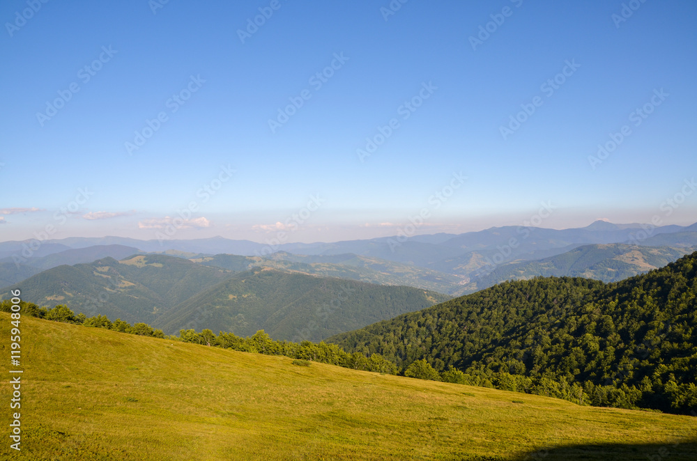 Peaceful scene featuring lush green hills with forest and tranquil mountain setting, under a clear blue sky. Carpathian Mountains, Ukraine Peaceful scene featuring lush green hills with forest and tranquil mountain setting, under a clear blue sky. Carpathian Mountains, Ukraine
