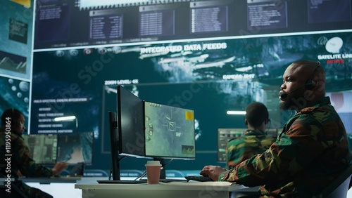 Government intelligence officer in high tech command post oversee satellite data, real time surveillance footage via radar cctv and coordinate operations. Protecting national interests. Camera B. photo