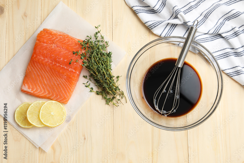 Φωτογραφία Soy sauce in bowl, whisk, salmon fillet, thyme and lemon slices on wooden table,