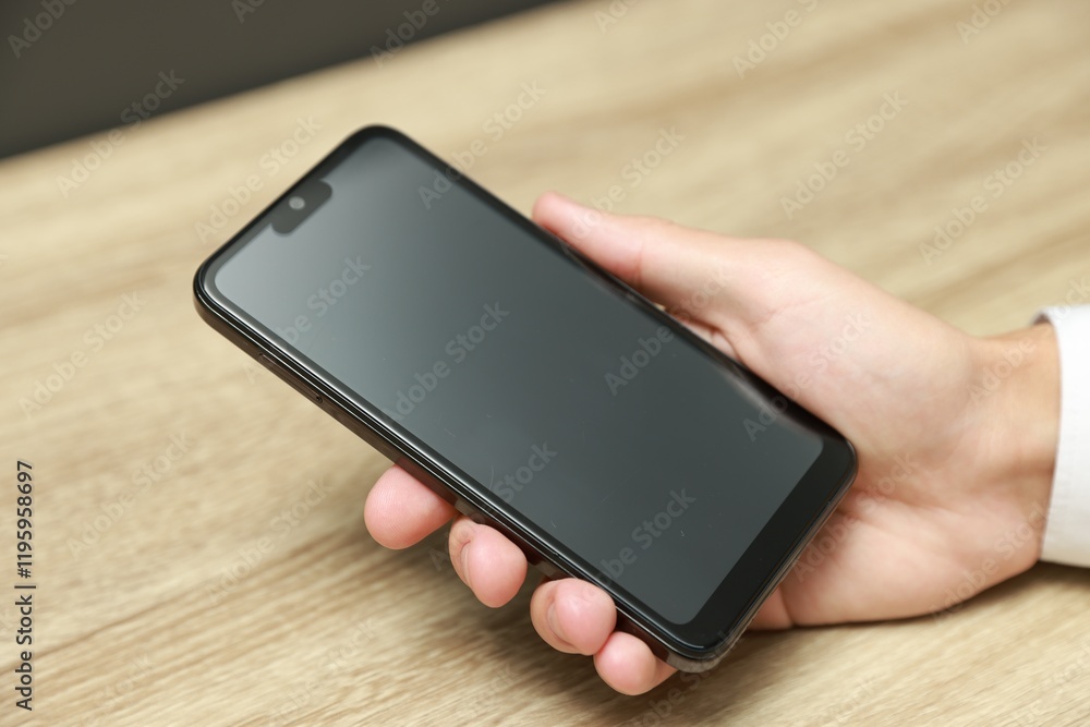 Man using smartphone with blank screen at wooden table, closeup Man using smartphone with blank screen at wooden table, closeup