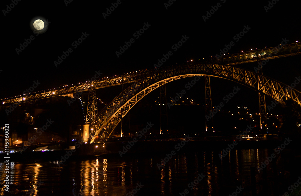 Naklejka premium Metallic bridge in the city of Porto at night with lighting on and full moon in the sky. Douro river downtown Porto, Dom Luís Bridge, Portugal