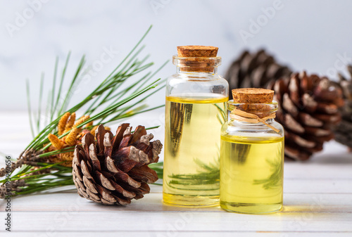 Pine turpentine essential oil in glass bottle with pine coniferous leaves and pine cone. Kiefer turpentin photo