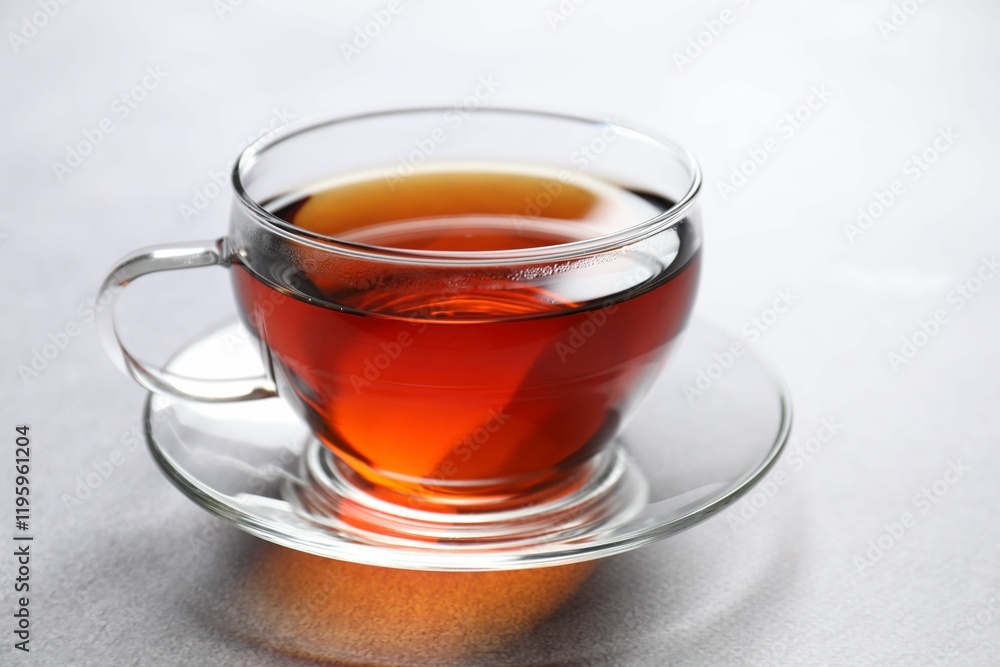 Aromatic black tea in cup on light table, closeup Aromatic black tea in cup on light table, closeup