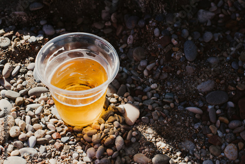 A glass of cold beer stands on the beach, capturing the essence of a relaxing, sunny day at the beach, an all-inclusive vacation photo