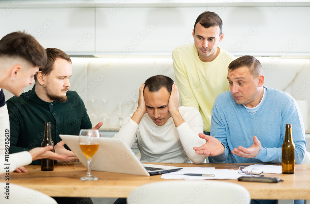 Fototapeta premium Men drink beer and try to help friend solve problems using laptop and the Internet