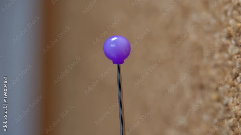 Close-up View of a Purple Decorative Pin on a Corkboard Backdrop During a Crafting Session Close-up View of a Purple Decorative Pin on a Corkboard Backdrop During a Crafting Session