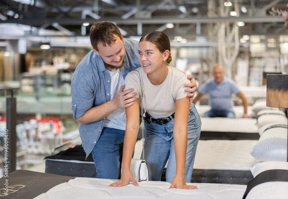 Married couple chooses a mattress on bed together in the store Married couple chooses a mattress on bed together in the store