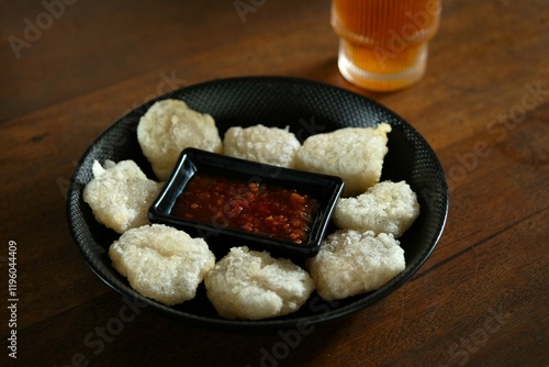 A plate of cireng on the table, served with chili sauce. Traditional snack from sundanese, made from tapioca flour and spice. photo