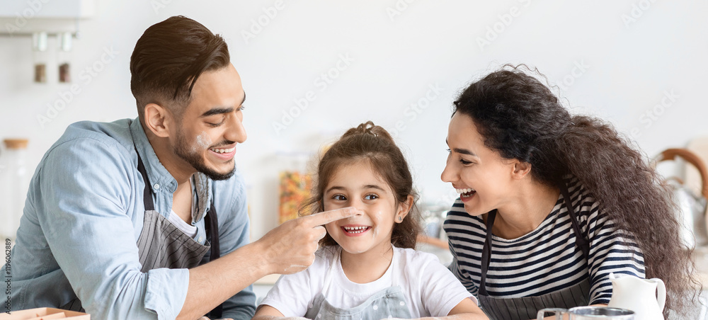 Cheerful family having fun while making biscuits at home, happy middle eastern father touching his laughing daughter nose, mom and dad enjoying weekend with child, kitchen interior Cheerful family having fun while making biscuits at home, happy middle eastern father touching his laughing daughter nose, mom and dad enjoying weekend with child, kitchen interior