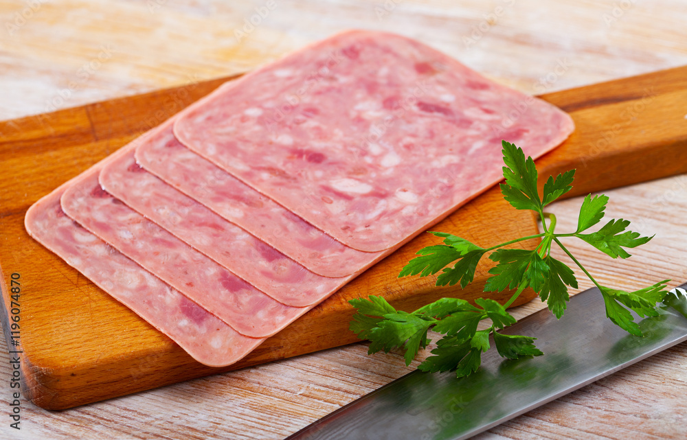 Sliced boiled pork ham served with parsley on wooden background Sliced boiled pork ham served with parsley on wooden background