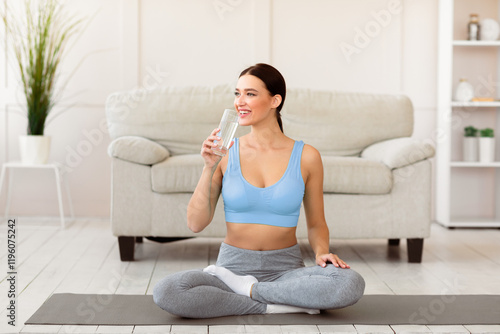 Healthy Lifestyle. Young Woman Drinking Water Sitting In Lotus Position On Yoga Mat At Home Free Download Healthy Lifestyle. Young Woman Drinking Water Sitting In Lotus Position On Yoga Mat At Home - GFXLoad