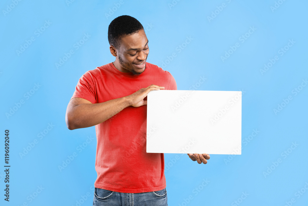 African American Guy Showing Empty White Board For Text Advertisement Posing Standing Over Blue Background In Studio. Man Holding Blank Paper Poster Advertising Something. Mockup African American Guy Showing Empty White Board For Text Advertisement Posing Standing Over Blue Background In Studio. Man Holding Blank Paper Poster Advertising Something. Mockup
