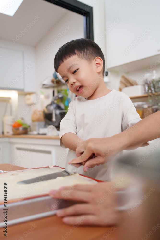Asian mother guides a young child baking a cake. Asian mother guides a young child baking a cake.