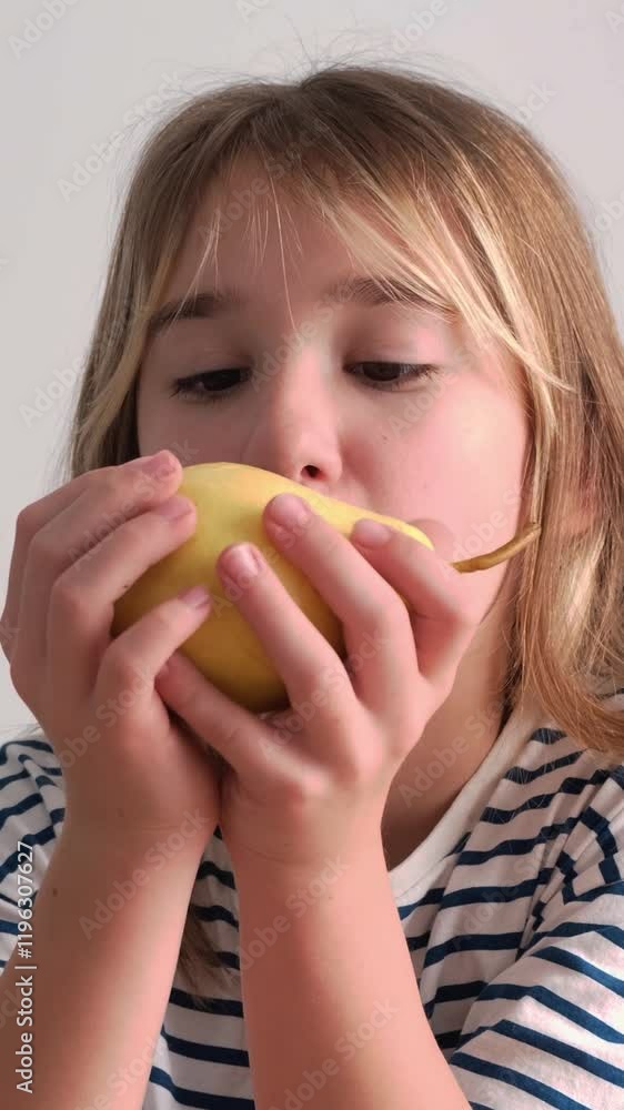 Close-up of a little girl eating a juicy apple. Vertical video Close-up of a little girl eating a juicy apple. Vertical video