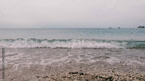 Waves crashing on the sand and shells of the beach