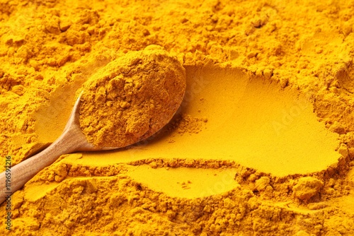 Photos Turmeric powder in spoon on spice, closeup. Space for text